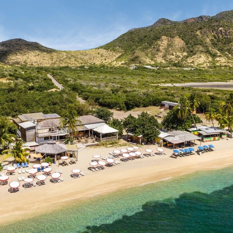 a beach with chairs and umbrellas and a building on the beach