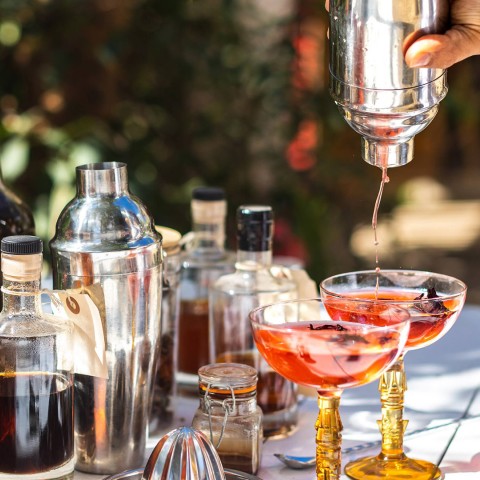 a person pouring a drink into a glass