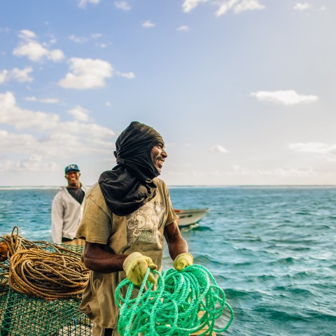 a man holding a rope and a boat in the water