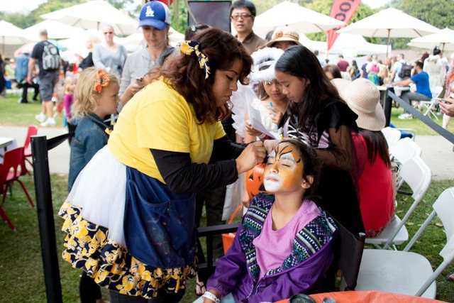 a woman painting a child's face