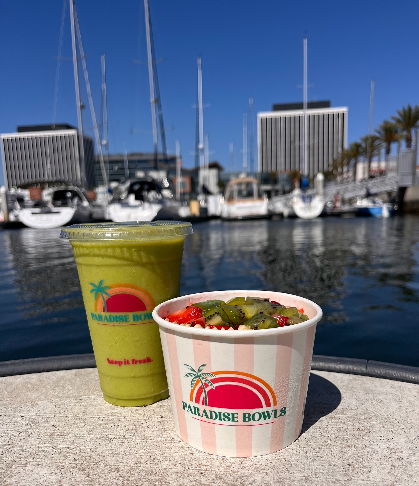a bowl of fruit and a drink on a boat