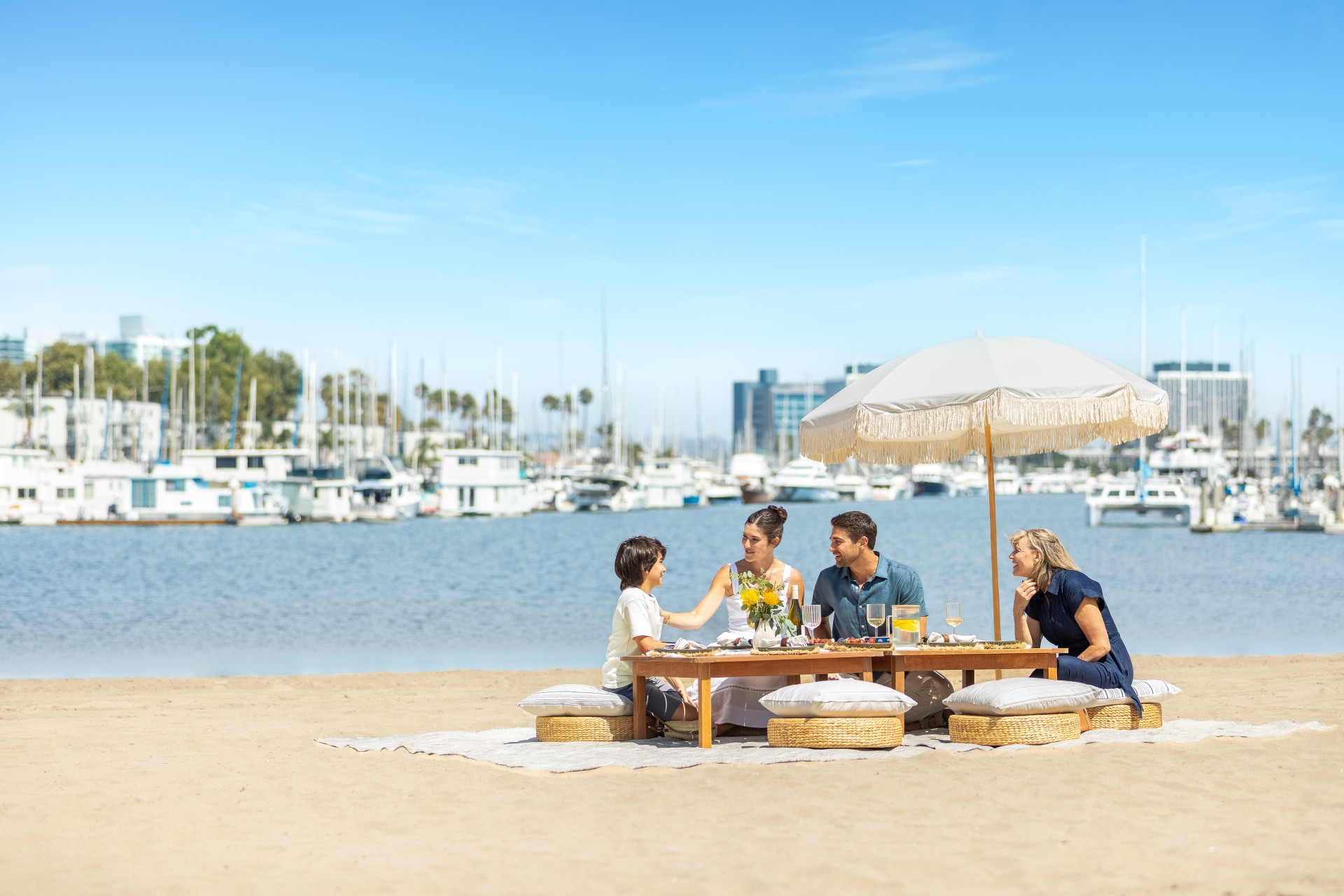 a group of people sitting at a table on a beach