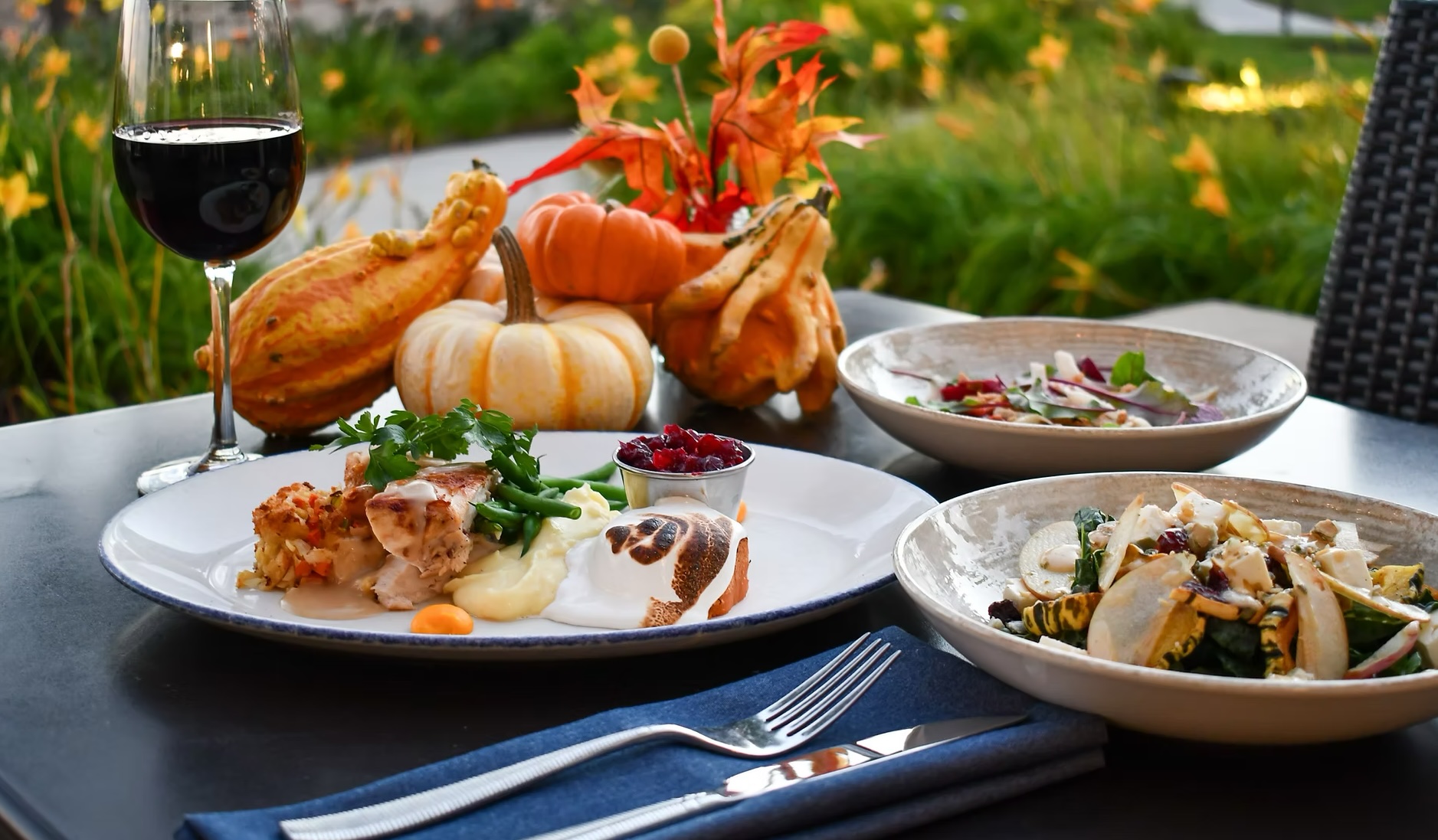 a table with plates of food and a glass of wine