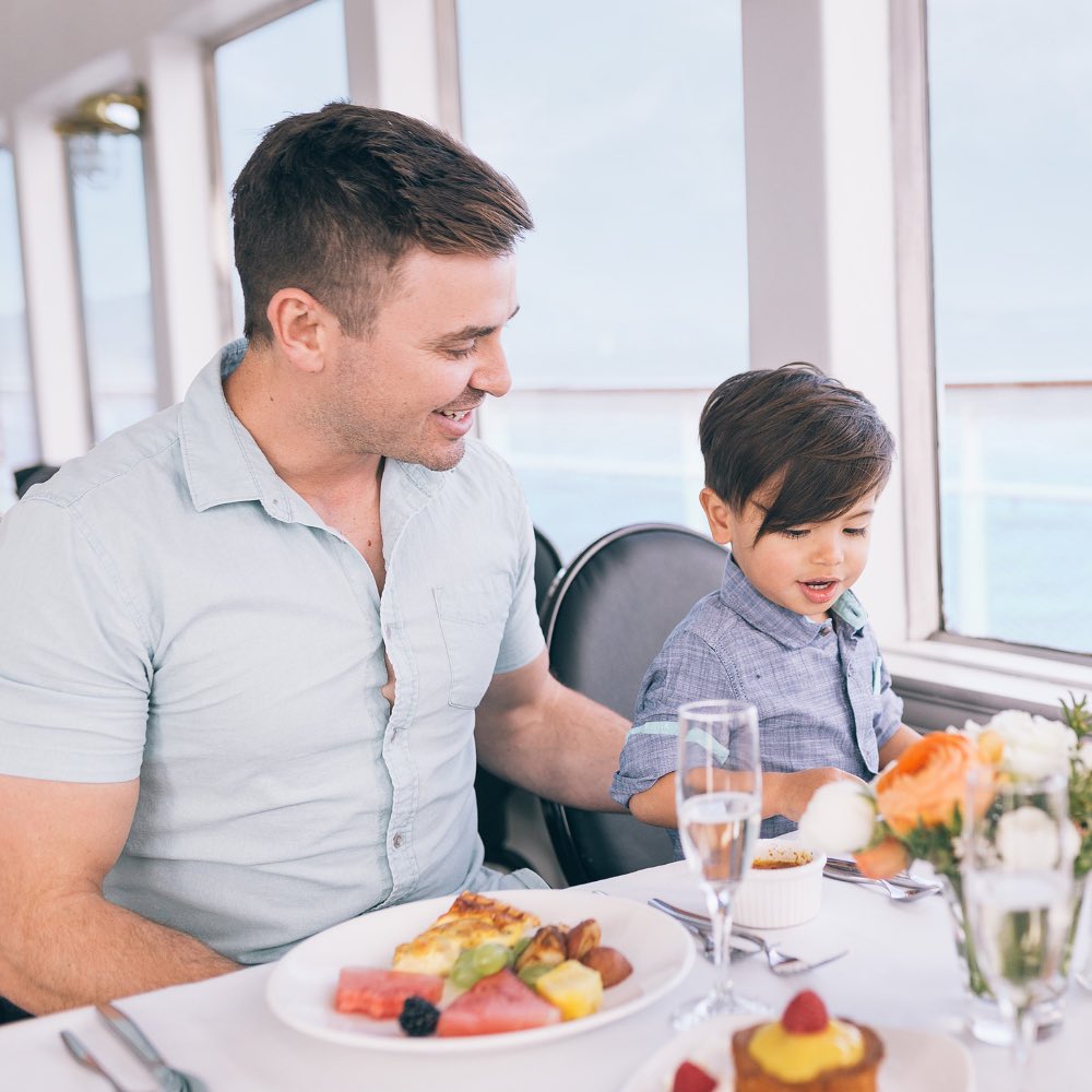 a man and child sitting at a table with food