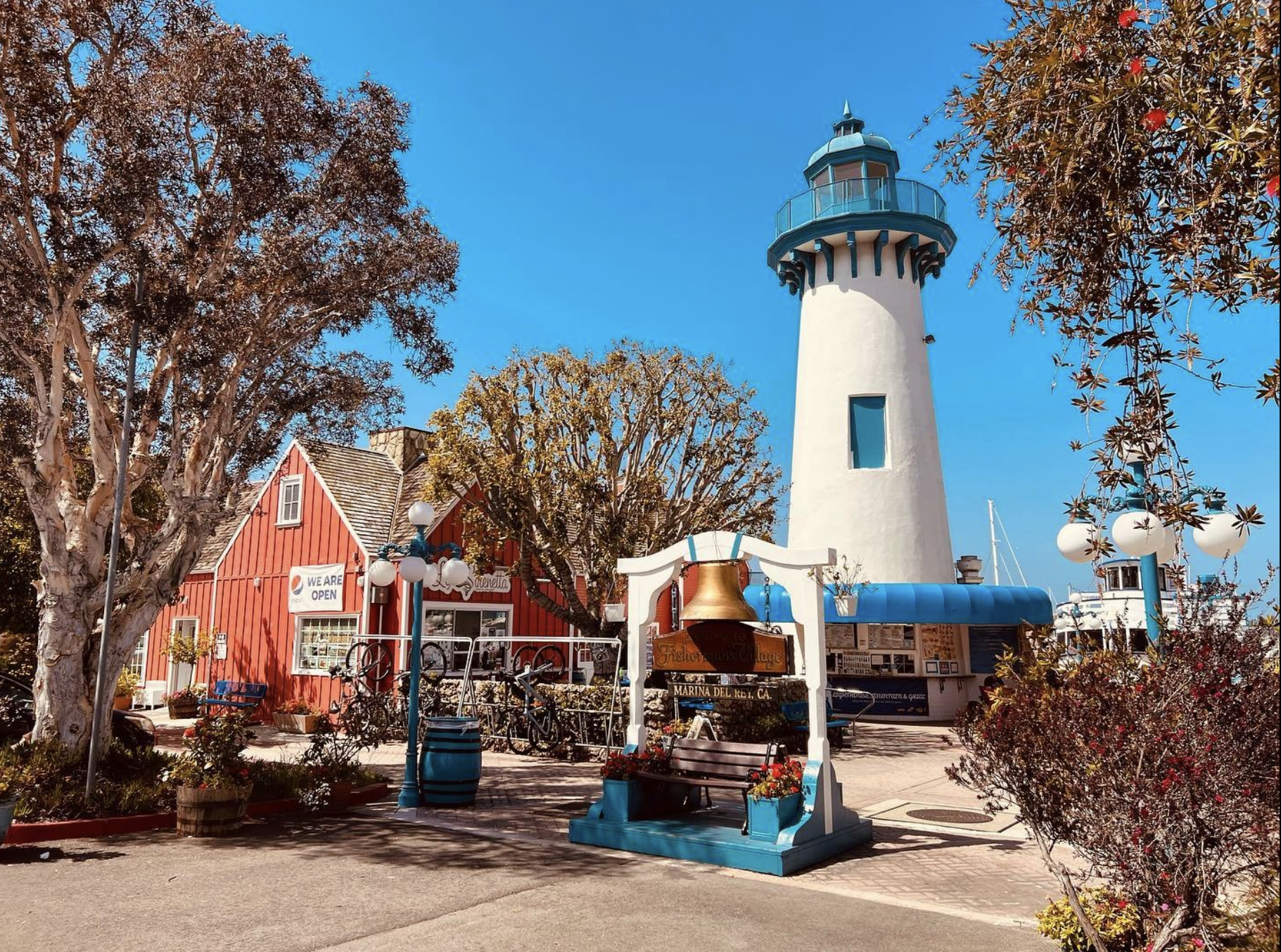 a lighthouse with a bell in front of a red building