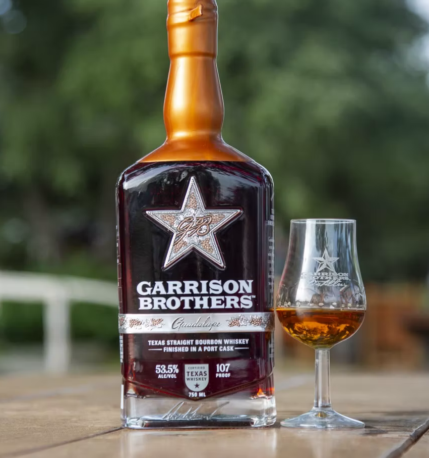 a bottle of alcohol next to a glass of alcohol
