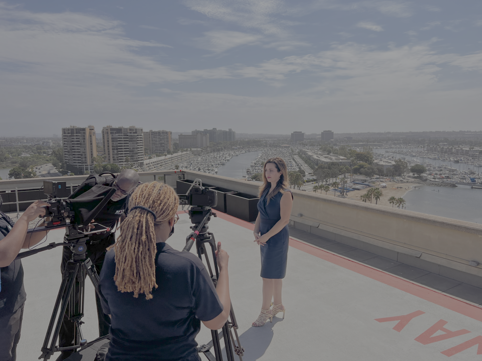 a woman standing on a roof with camera equipment and a woman standing on a roof