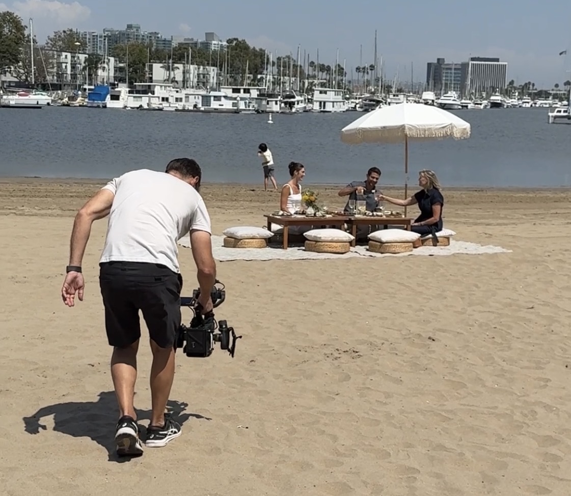 a man holding a camera on a beach