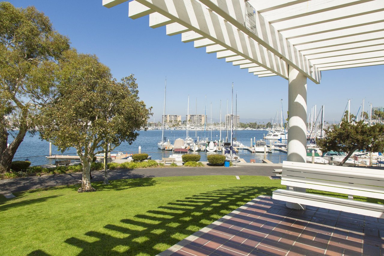 a white bench on a patio overlooking a body of water