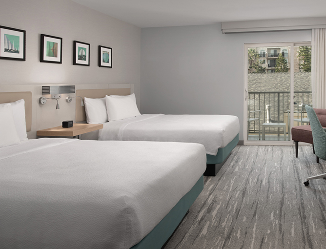 a room with two beds and a glass door