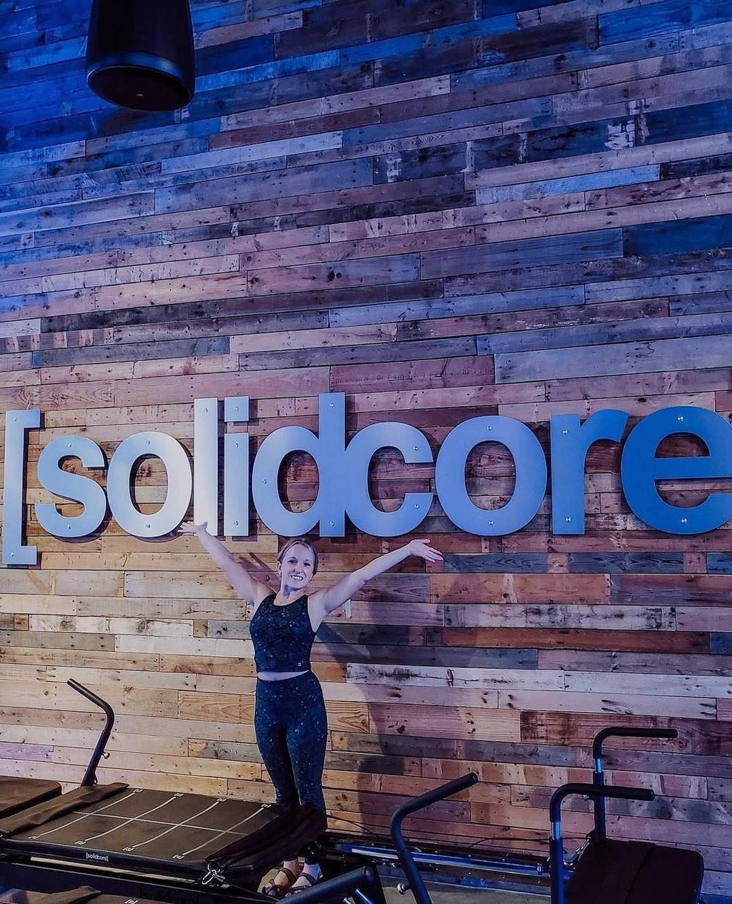 a woman standing in front of a wall with text