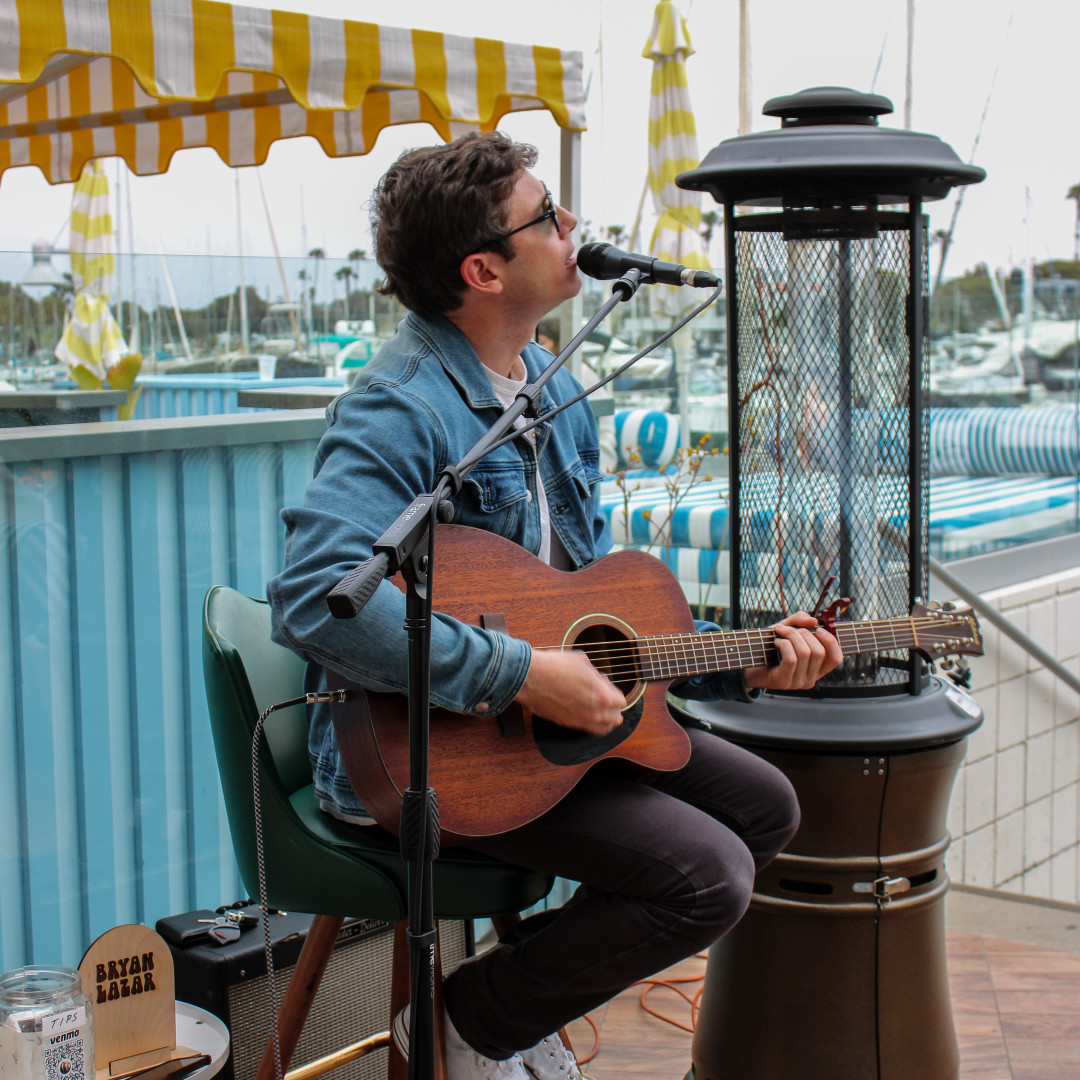 a man playing guitar and singing into a microphone