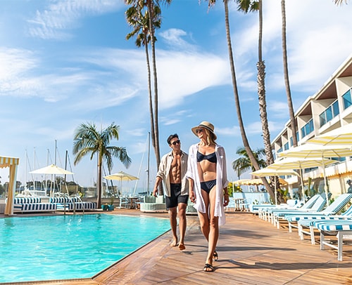 a man and woman walking by a pool
