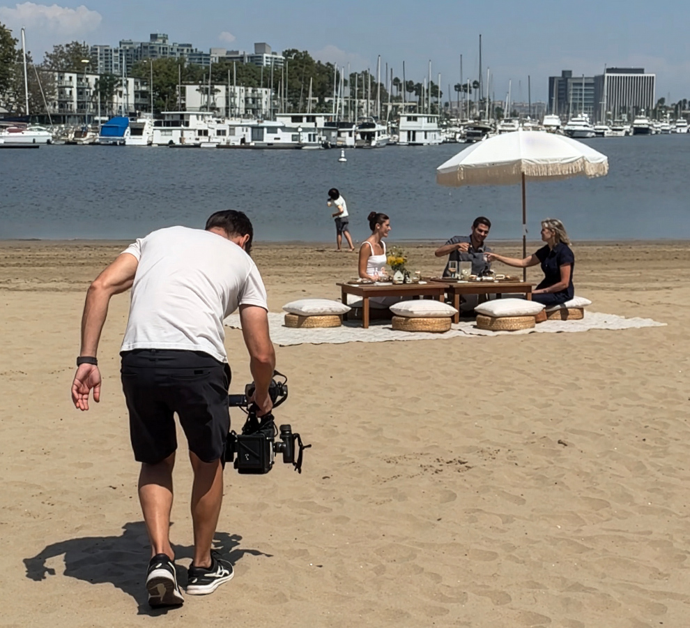 a man holding a camera on a beach
