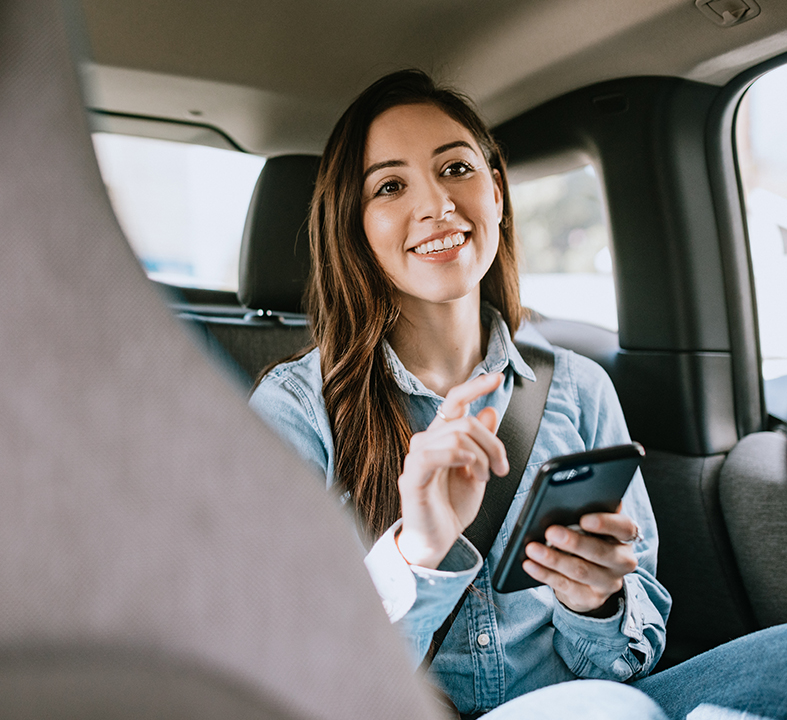 a woman sitting in a car holding a phone