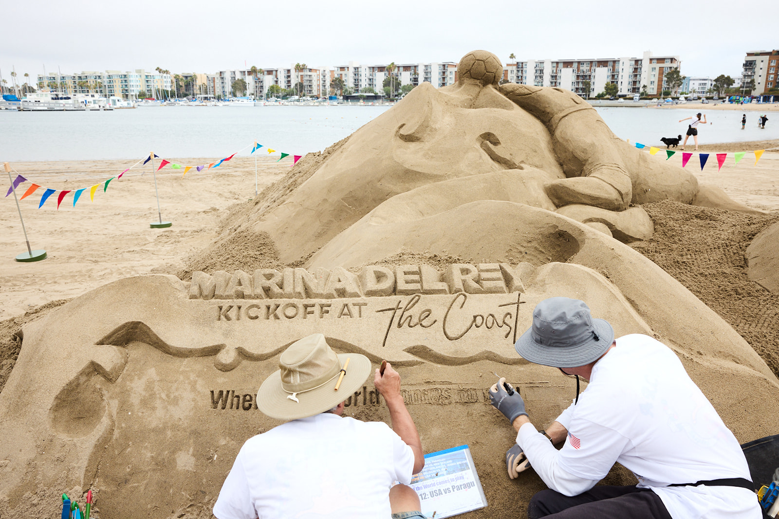 a group of people writing on sand