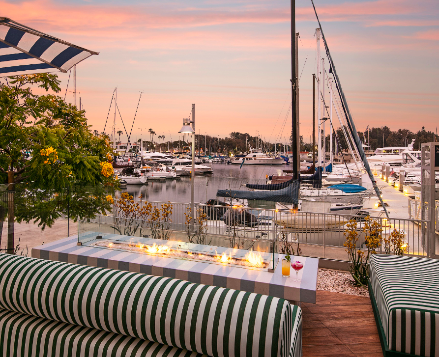 a dock with boats and a bar with a fire pit