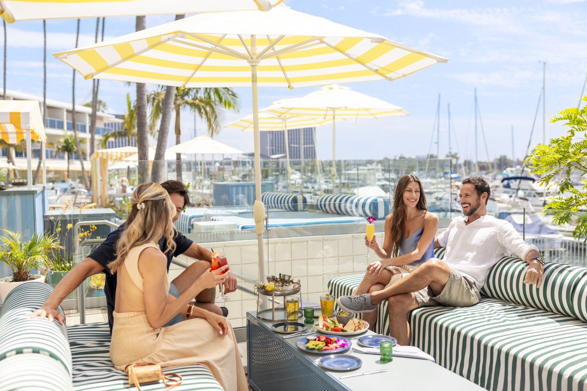 a group of people sitting on a table with food and drinks