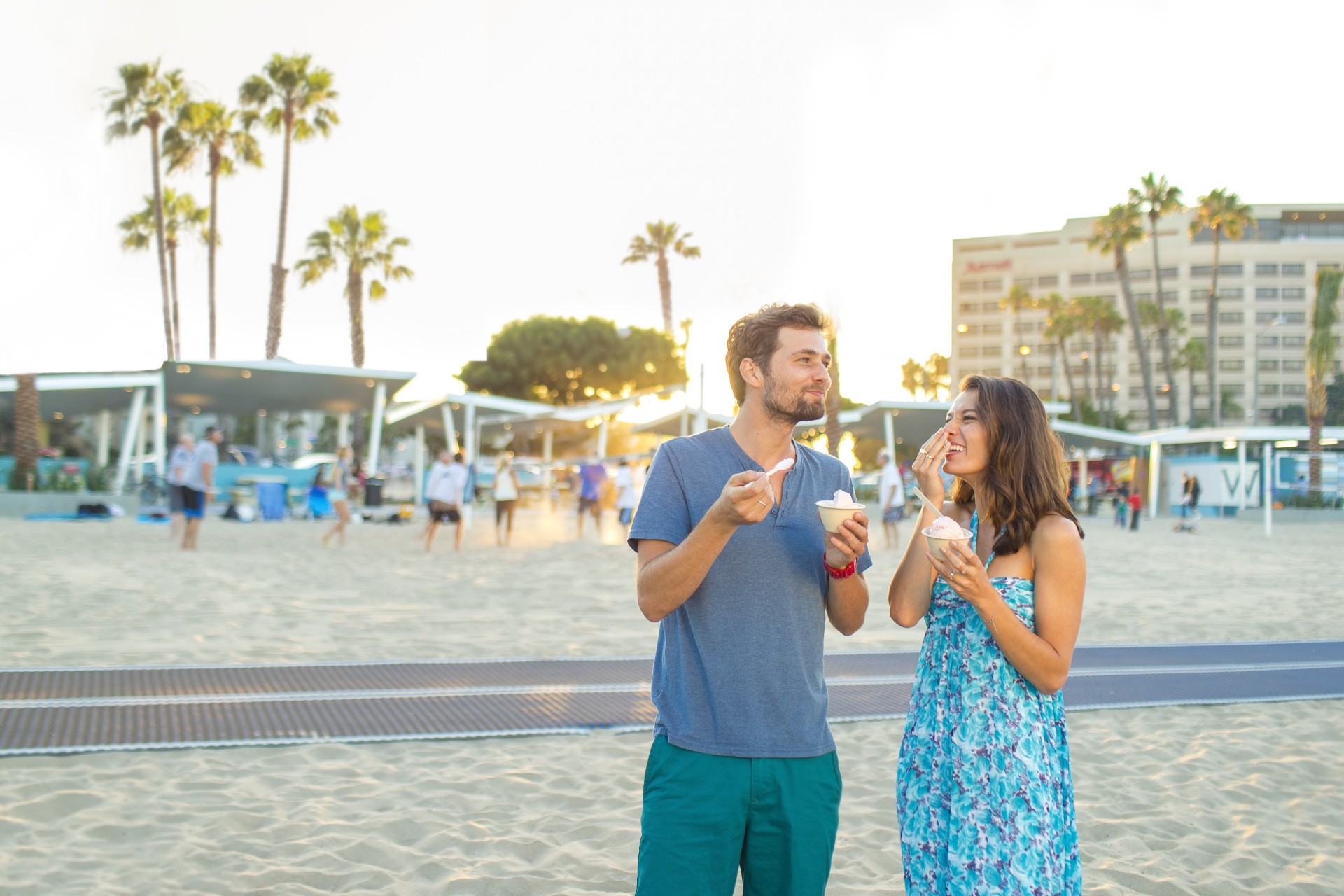 a man and woman eating ice cream on a beach