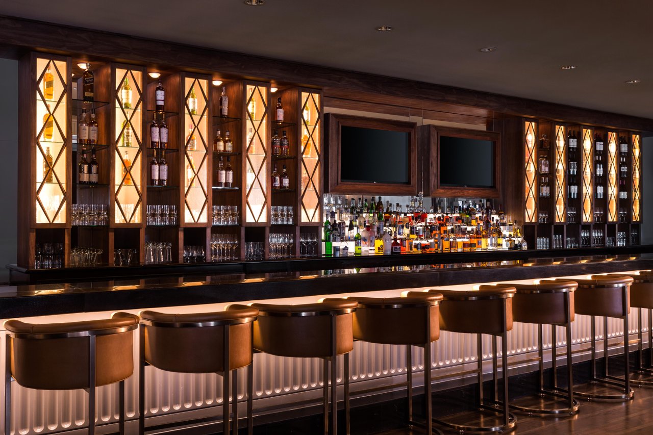 a bar with a row of bottles and shelves