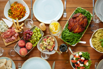 a table with plates of food and a glass of wine