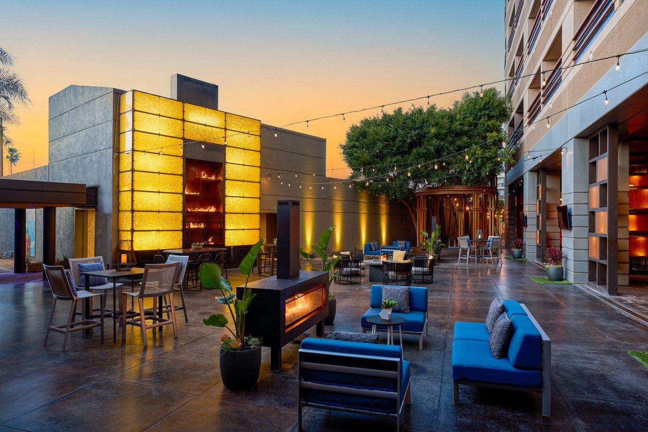 a patio with chairs and tables and a fireplace