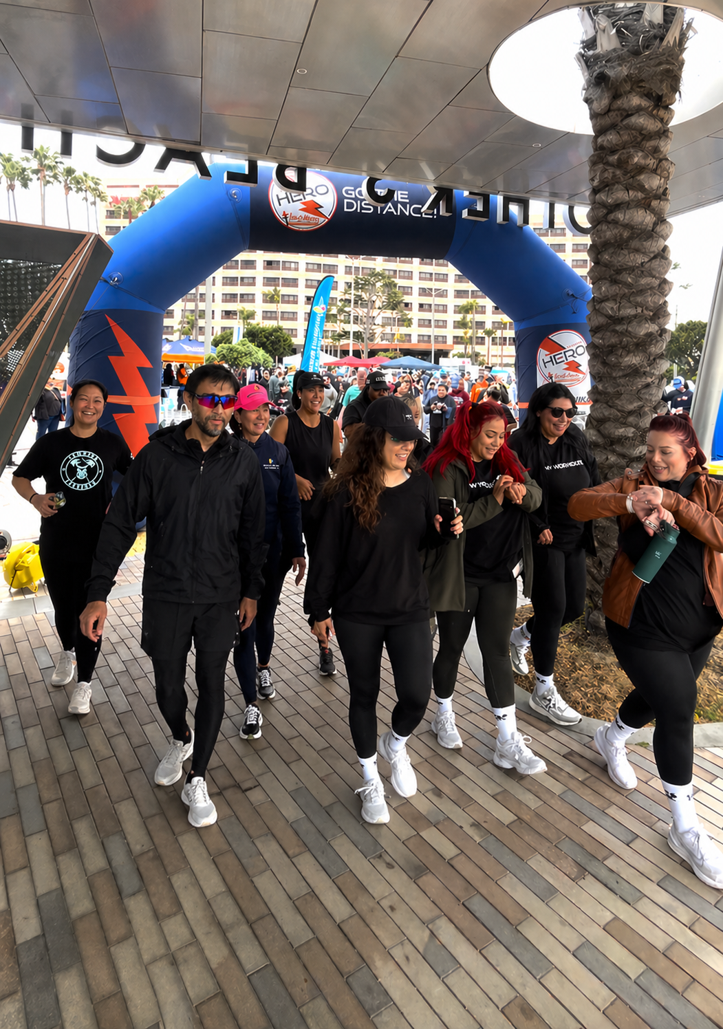 a group of people walking under a blue arch