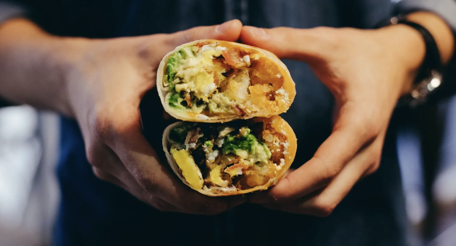 a person holding a burrito