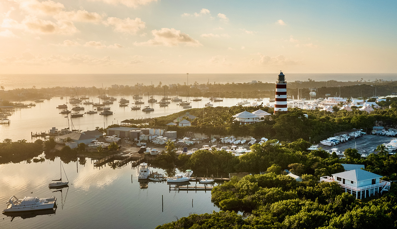 a lighthouse on a body of water with boats in the background