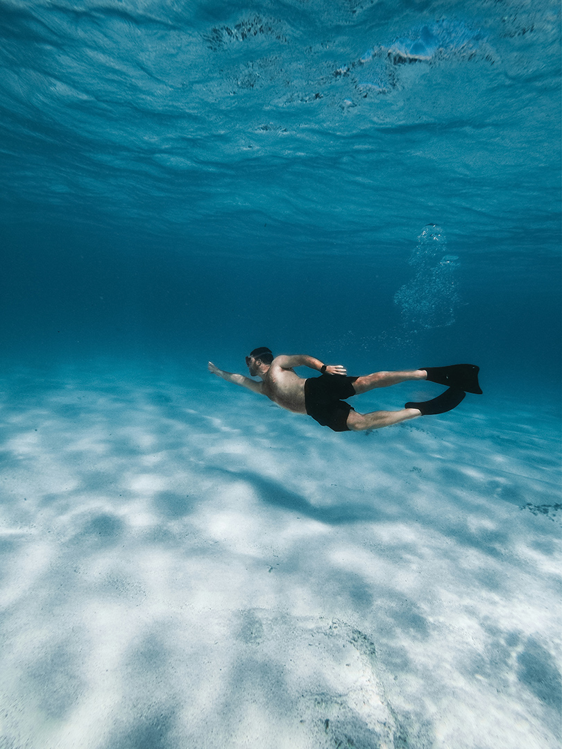 a man swimming underwater in the ocean