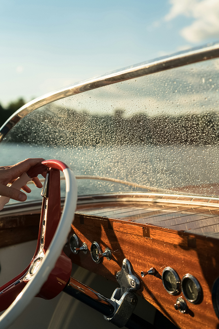 a hand on steering wheel of a boat
