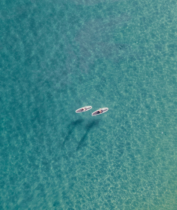 a couple of people on surfboards in the water