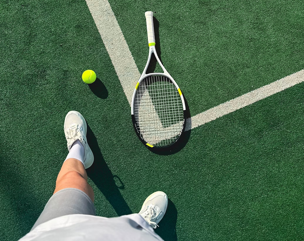 a tennis racket and ball on a tennis court