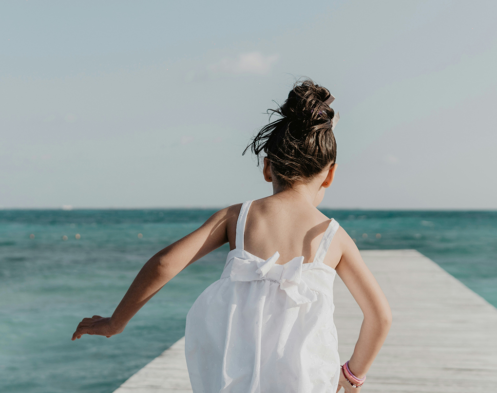 a girl in a white dress on a dock