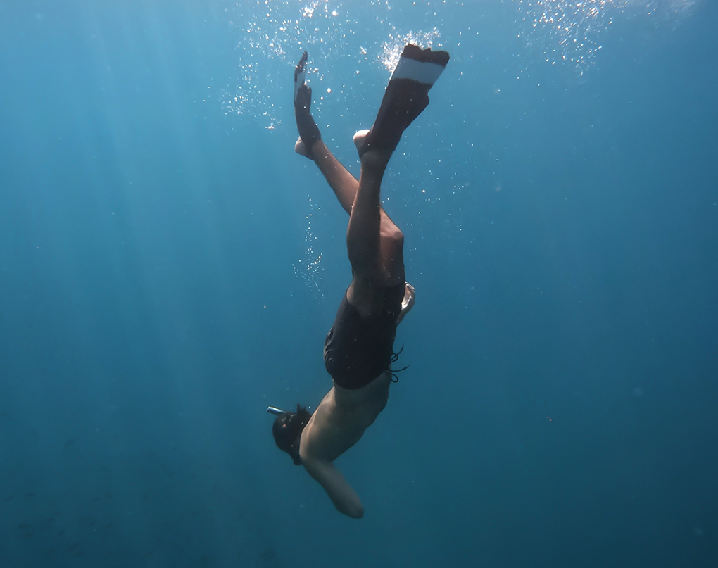 a person swimming underwater with fins