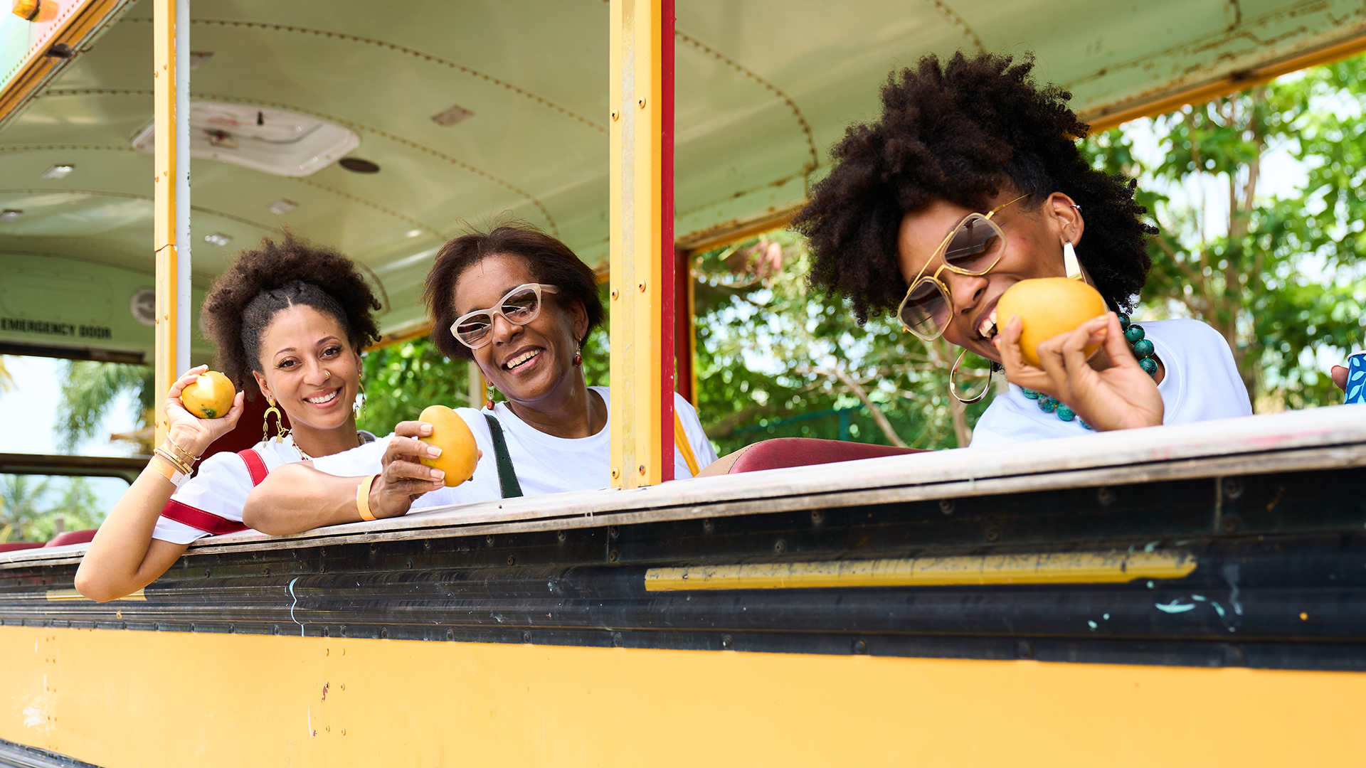 a group of women smiling and holding fruit