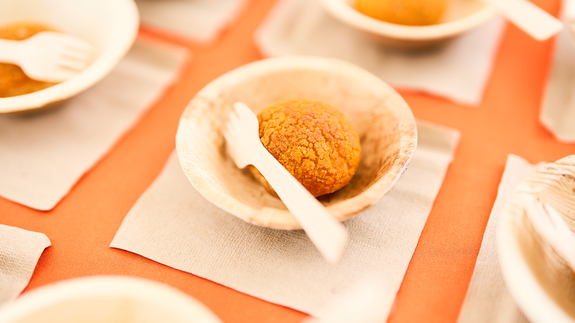 a bowl with a wooden fork and a round object