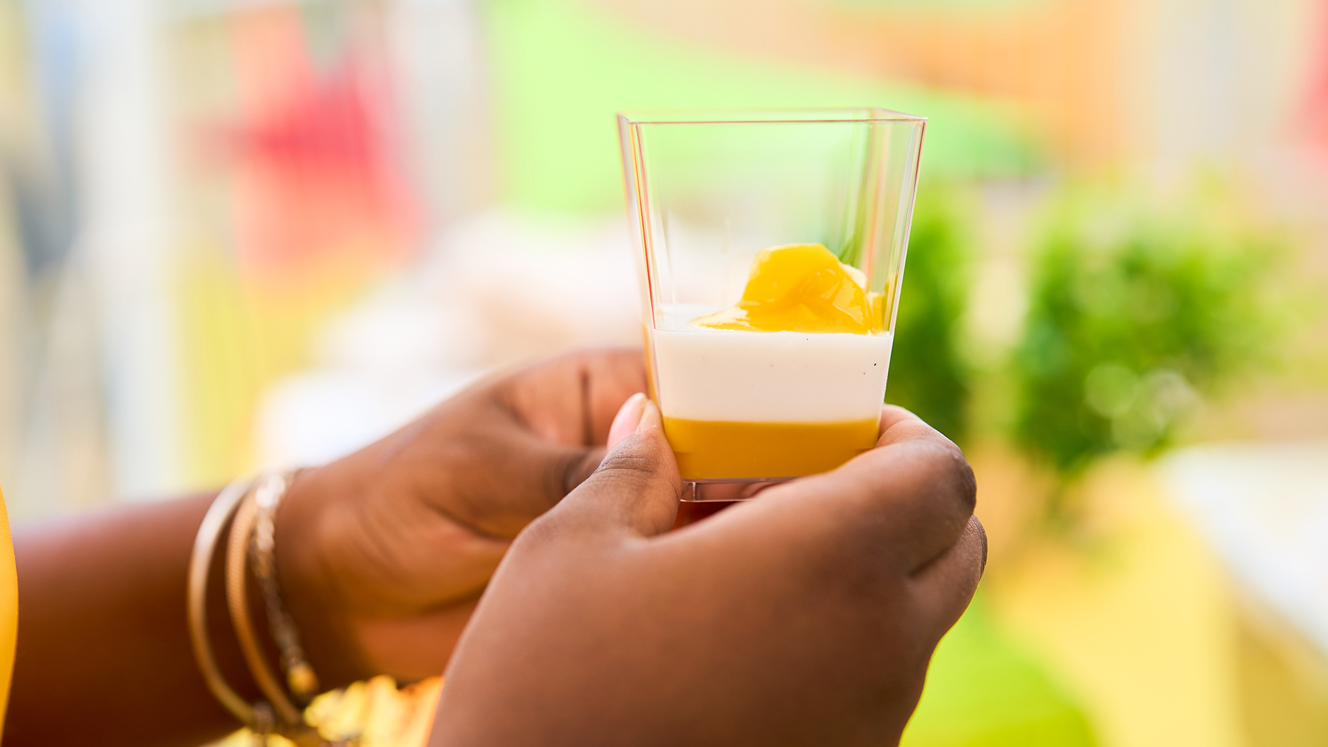 a person holding a glass of yellow liquid