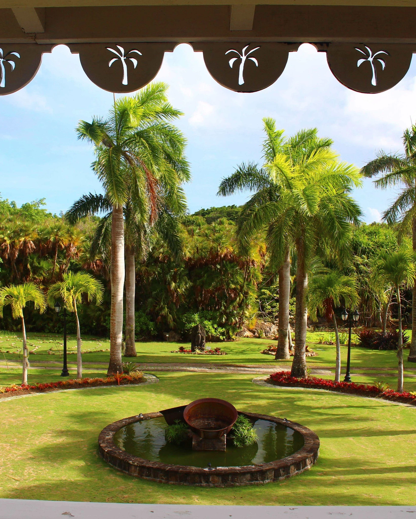 a fountain in a park with palm trees