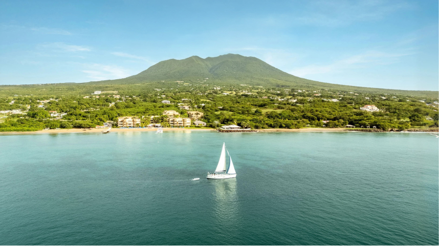 a sailboat in the water with a mountain in the background