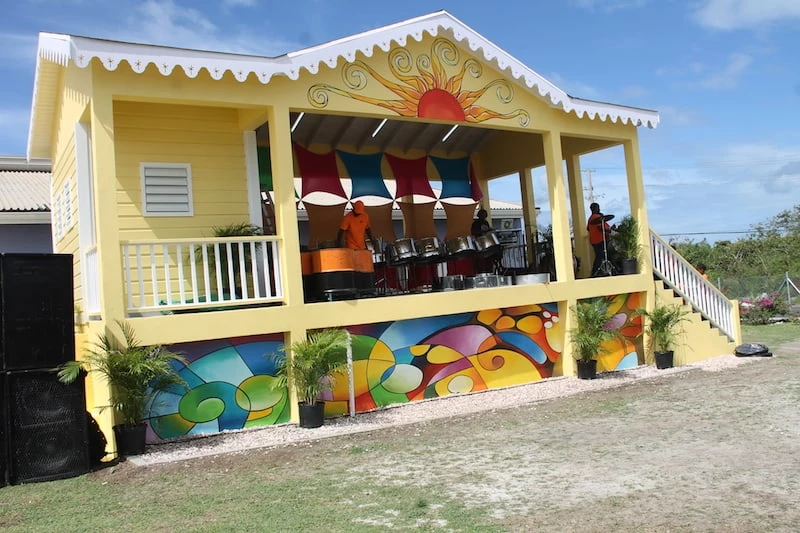 a yellow house with a colorful wall and a band on the stage