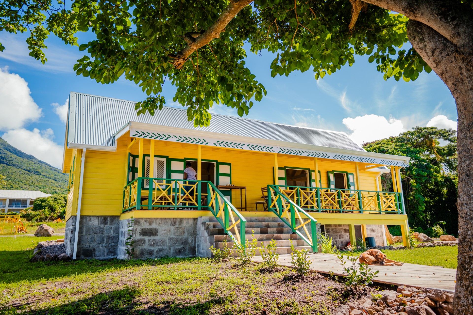 a yellow house with green railings
