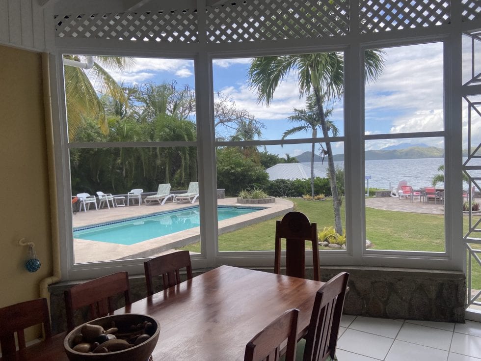 a dining table with chairs and a pool outside