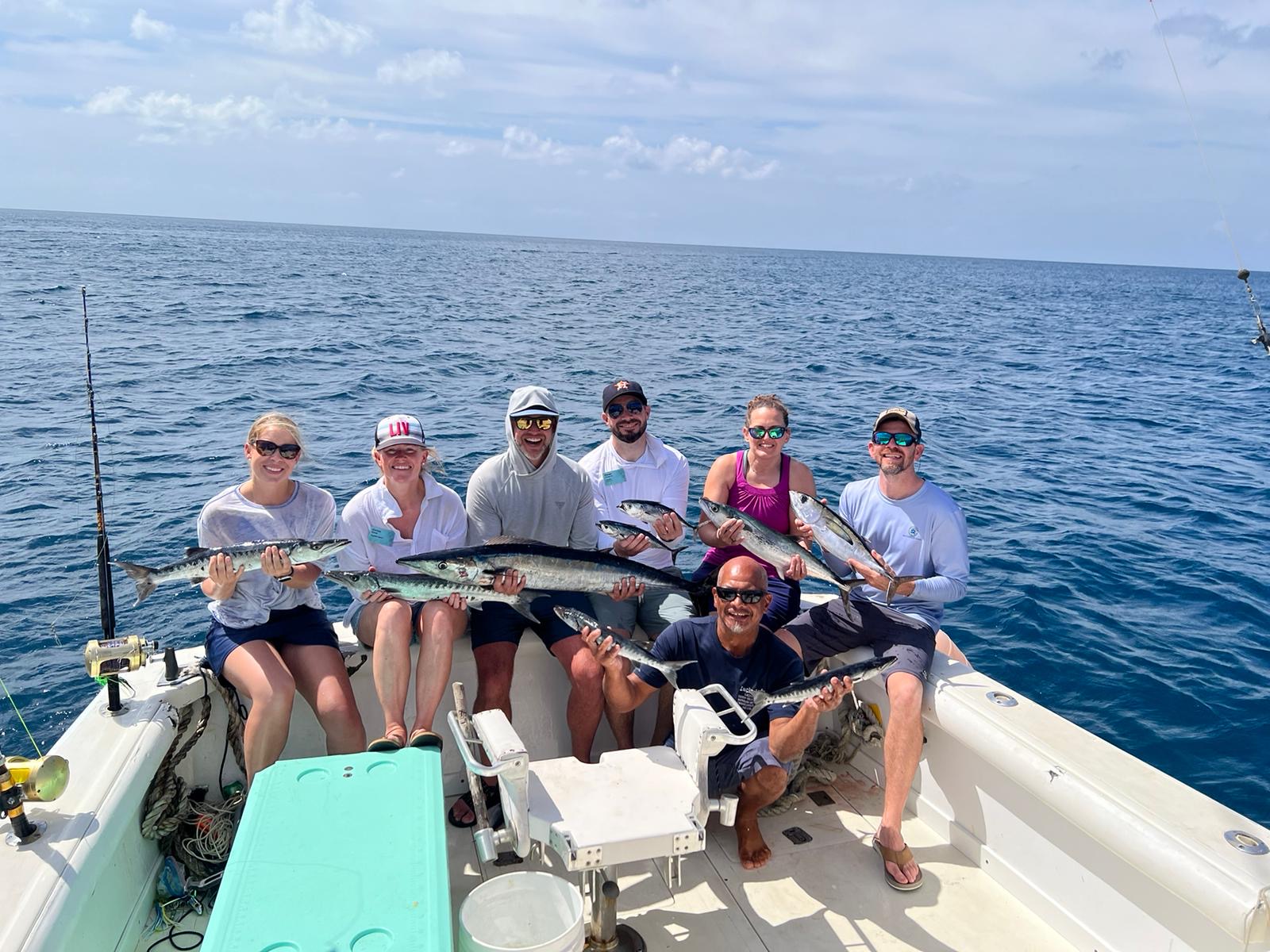 a group of people on a boat holding fish