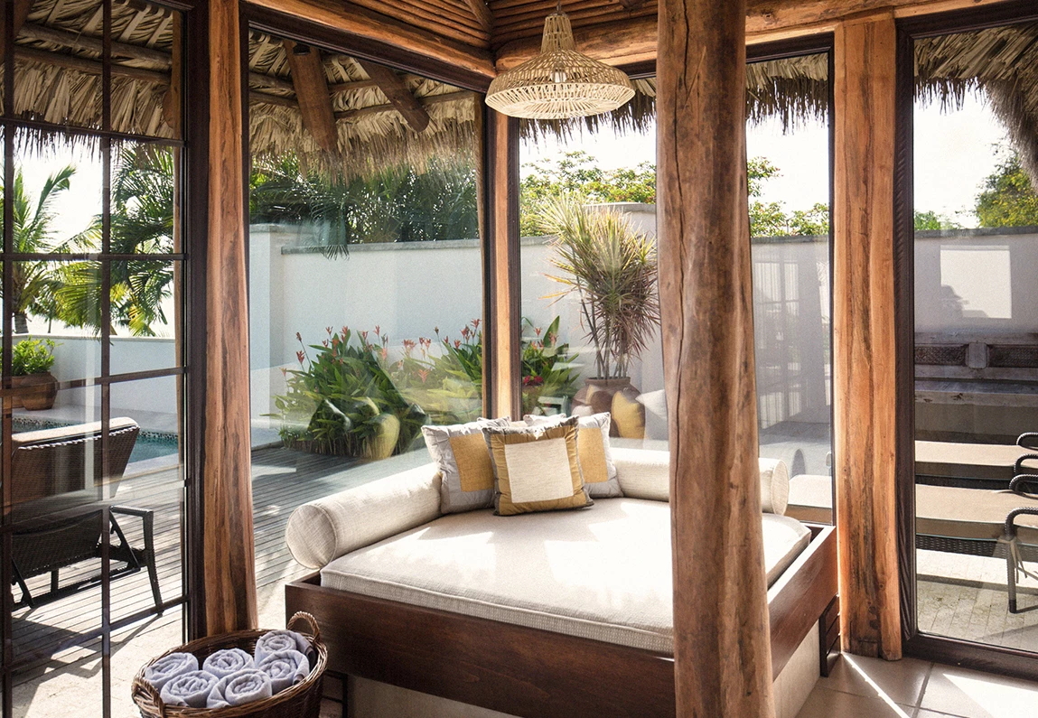 a room with a bed and a pool in the background