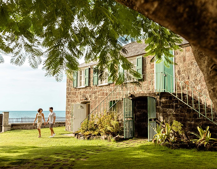 a man and woman walking in front of a stone building