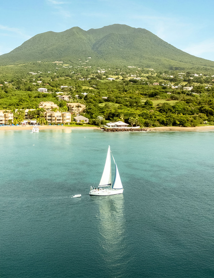 a sailboat in the water with a mountain in the background