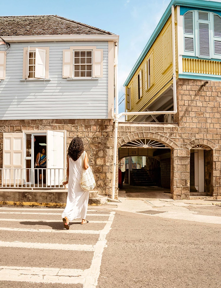 a woman in a white dress crossing a street