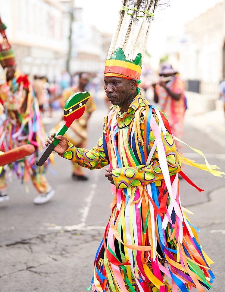 a man in colorful garment holding a maracas