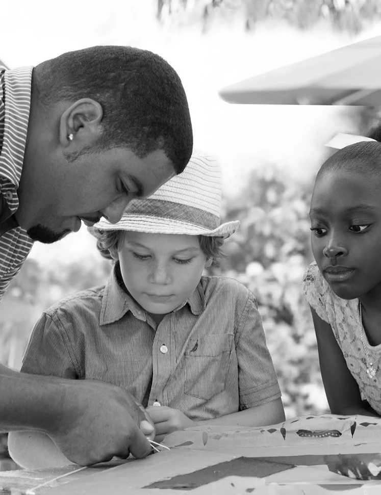a man and children looking at a piece of paper